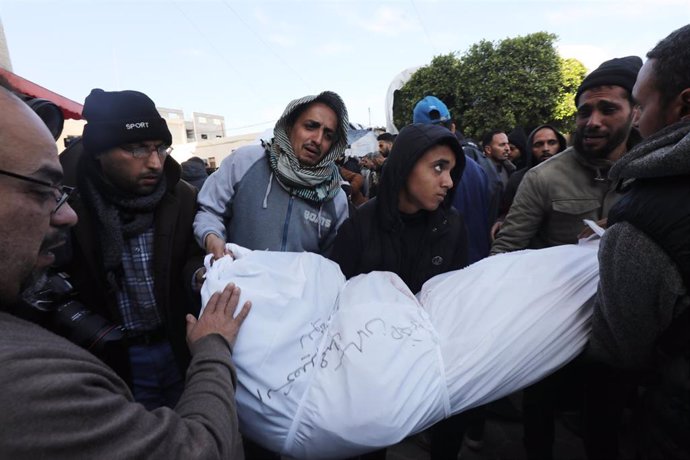 Un grupo de palestinos acarrean el cadáver de un familiar frente a las puertas del hospital Al Aqsa.