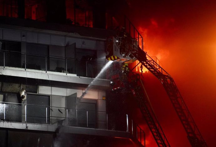 Un bombero trata de apagar el edificio en llamas