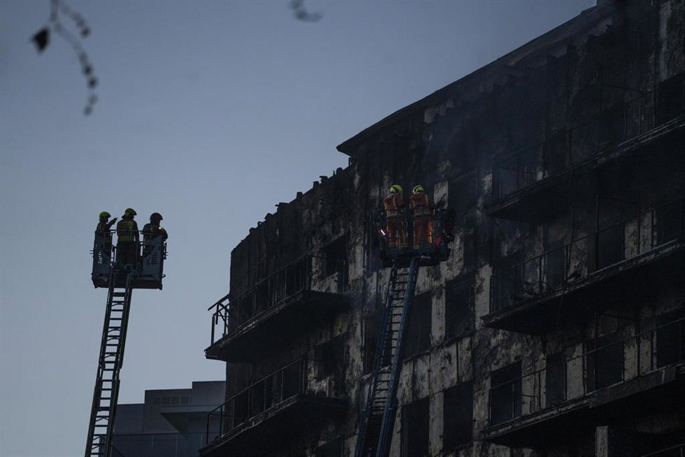 Los bomberos trabajan en el incendio en el barrio de Campanar. 