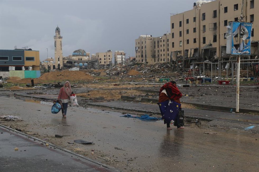 Archivo - Palestinos caminan por una calle de la ciudad de Beit Lahia, en el norte de la Franja de Gaza, en el marco de la ofensiva del Ejército de Israel (archivo)