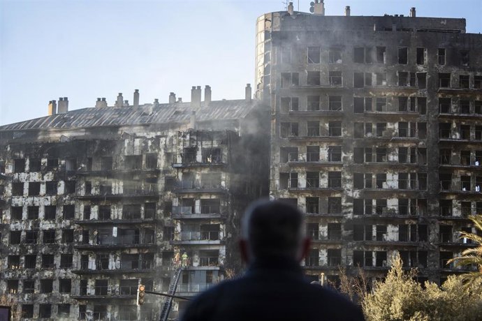 Un hombre observa la estructura del edificio tras el incendio de ayer, 22 de febrero, en el barrio de Campanar, a 23 de febrero de 2024, en Valencia