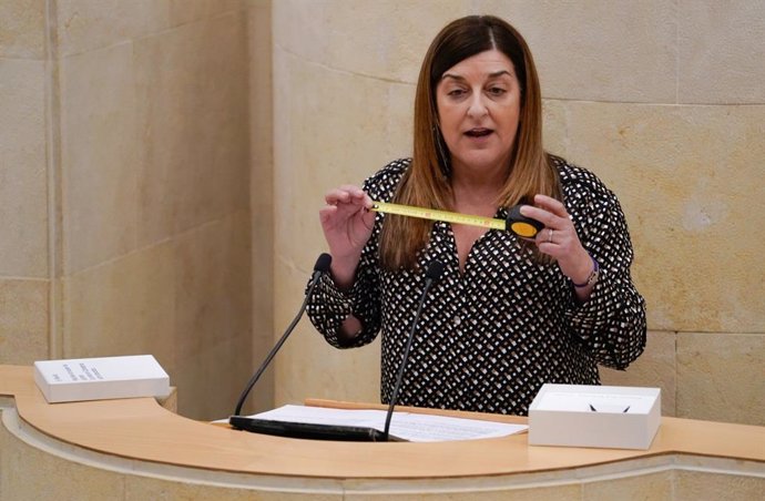 Archivo - La presidenta de Cantabria, María José Sáenz de Buruaga, con una cinta métrica en el Parlamento, en una intervención tras el problema de las medidas de los trenes que no cabían por los túneles