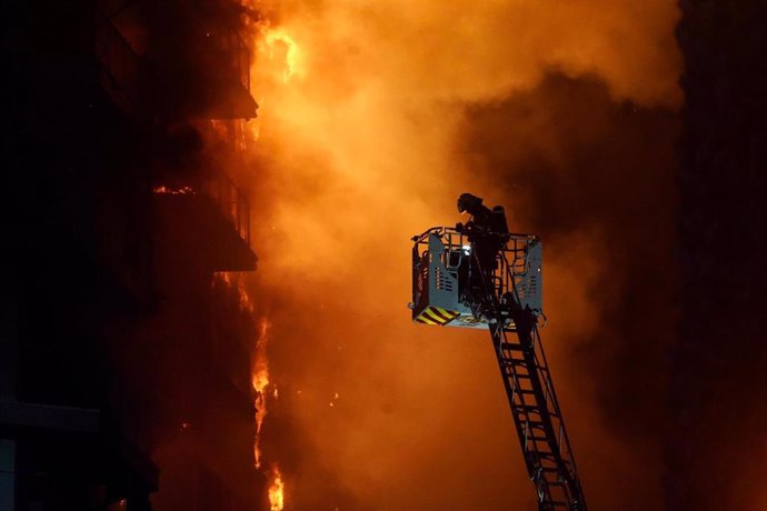 Un bombero trata de apagar el edificio en llamas, en el barrio de Campanar, a 22 de febrero de 2024, en Valencia, Comunidad Valenciana (España). Un incendio de grandes dimensiones ha arrasado un edificio de 14 plantas en el barrio valenciano de Campanar. 
