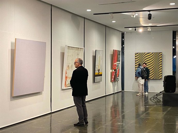 Un asistente a la exposición del certamen de pinturas de Grúas Lozano.