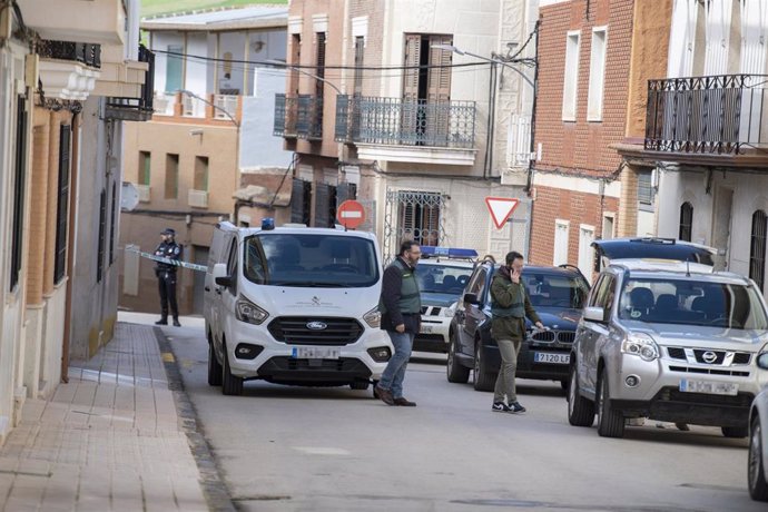 Dos agentes de la Guardia Civil y un vehículo funerario de recogida en las inmediaciones del lugar donde se ha producido el asesinato a una mujer, a 23 de febrero de 2024, en Aldea del Rey.