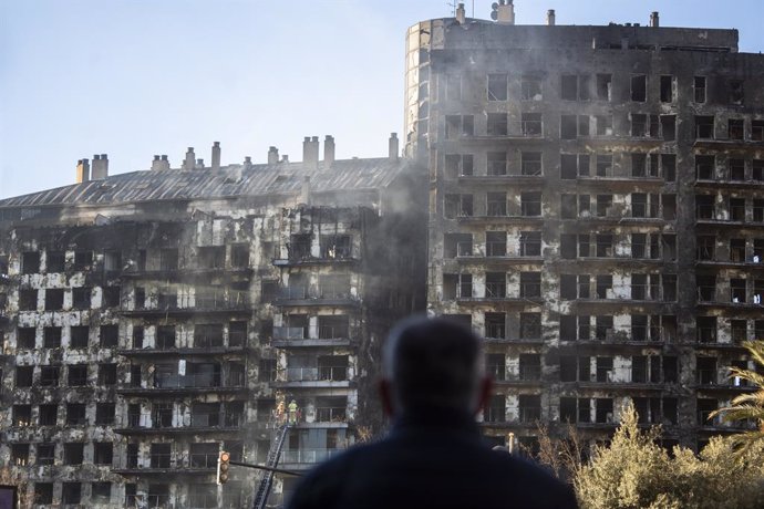 Un hombre observa la estructura del edificio tras el incendio de ayer, 22 de febrero, en el barrio de Campanar, a 23 de febrero de 2024, en Valencia, Comunidad Valenciana (España). Un incendio de grandes dimensiones arrasó ayer un edificio de 14 plantas