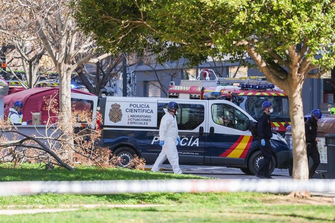 Un vehículo y agentes de la Policía Científica se dirigen a entrar en el edificio tras el incendio de ayer. 