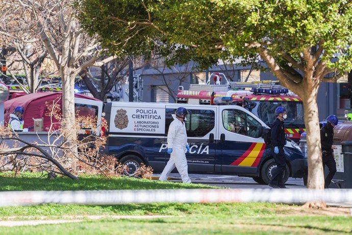 Un vehicle i agents de la Policia Científica es dirigeixen a entrar a l'edifici després de l'incendi d'ahir. 