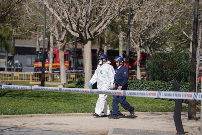 Dos agents de la Policia Científica es dirigeixen a entrar en l'edifici després de l'incendi 