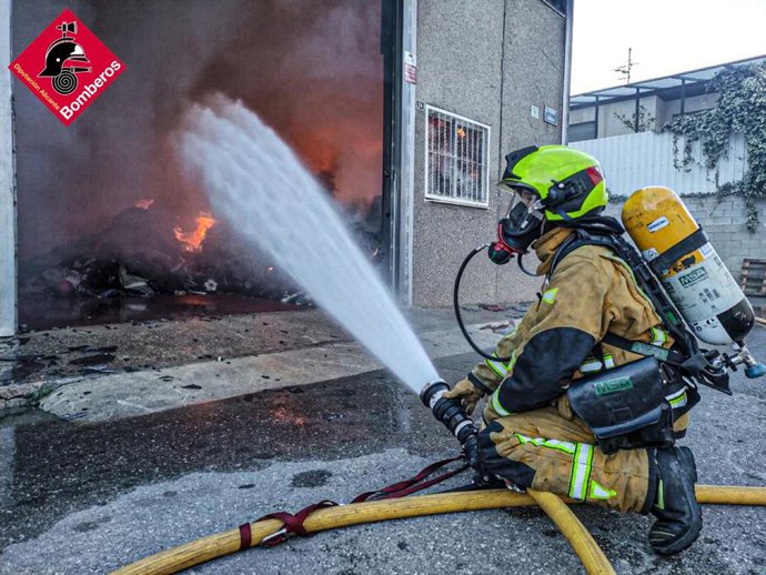 Un bombero trabajando en el incendio de la nave de Alcoy