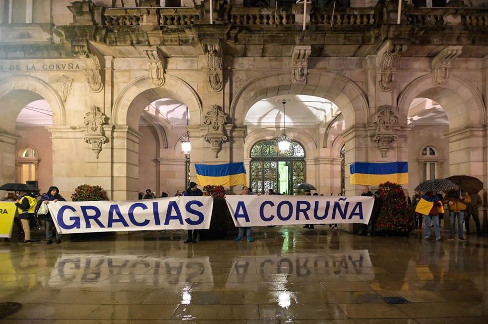 Archivo - Un grupo de personas sujetan banderas de Ucrania junto a una pancarta donde pone 'Gracias A Coruña' durante una manifestación contra la invasión rusa de Ucrania, a 24 de febrero de 2023, en A Coruña, Galicia (España).