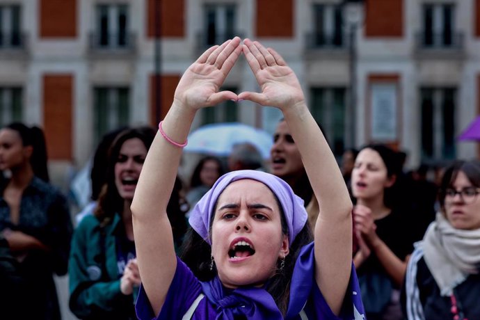 Archivo - Una mujer protesta haciendo un símbolo feminista con las manos durante una concentración, en imagen de archivo. 