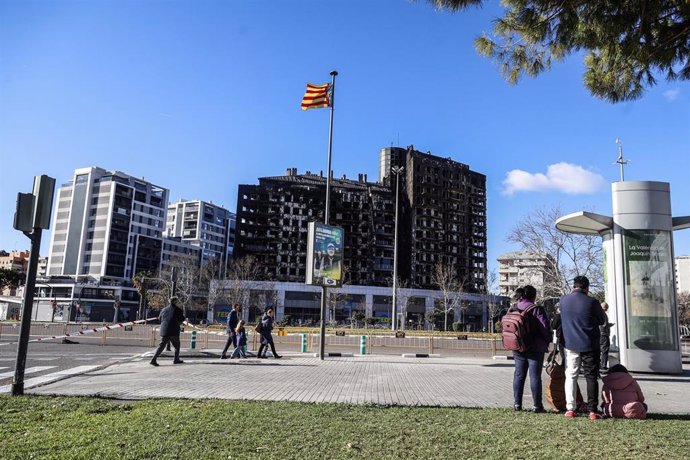 Varias personas observan el edificio incendiado del barrio de Campanar, a 24 de febrero de 2024, en Valencia