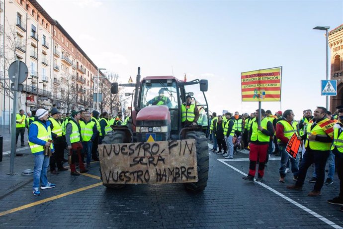 Decenas de agricultores junto a un tractor durante una manifestación, a 23 de febrero de 2024, en Teruel.