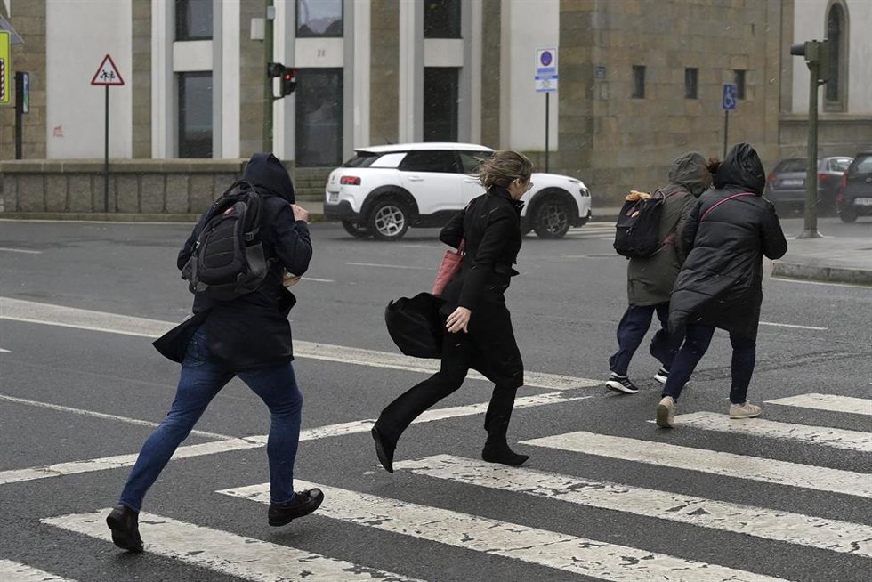 Varias personas corren bajo la lluvia durante el frente meteorológico, a 23 de febrero de 2024, en A Coruña, Galicia (España). La Agencia Estatal de Meteorología (Aemet) decretó un aviso naranja por temporal costero en el litoral gallego que ya está act