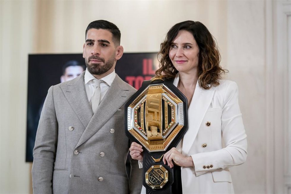 El campeón del mundo de peso pluma de la Ultimate Fighting Championship (UFC), Ilia Topuria y la presidenta de la Comunidad de Madrid, Isabel Díaz Ayuso, posan con el cinturón de la UFC, en la Real Casa de Correos