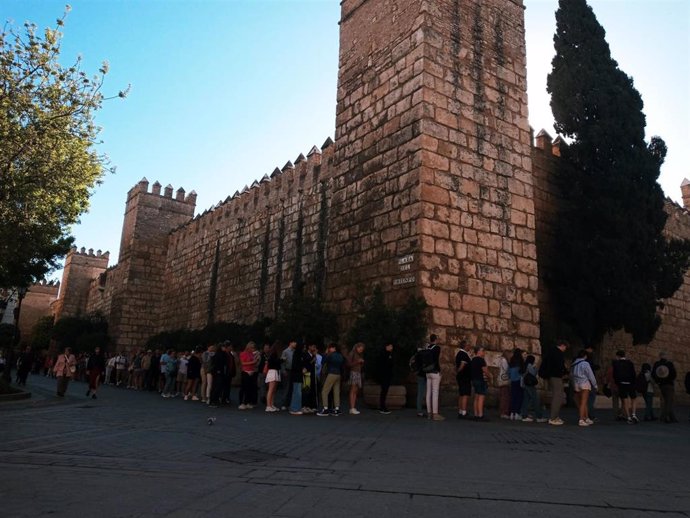 Archivo - Decenas de personas guardan cola para acceder al Alcázar de Sevilla.