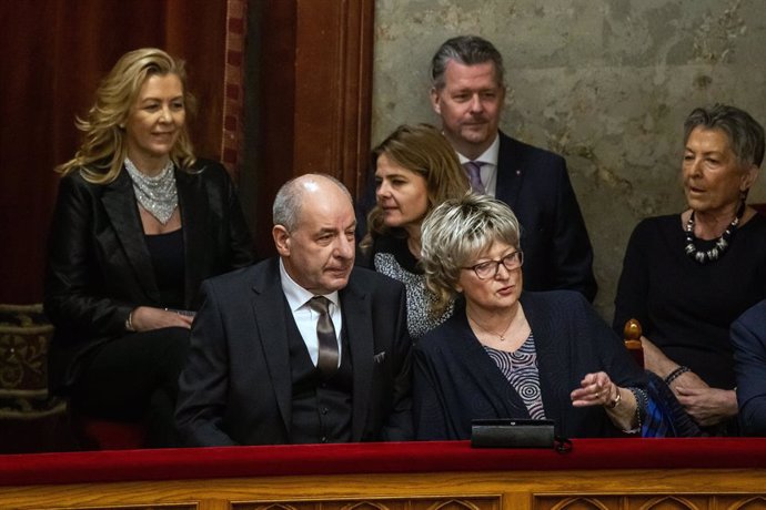 26 February 2024, Hungary, Budapest: Tamas Sulyok (L), the only candidate for the office of Hungarian president, proposed by Fidesz, sits with his relatives in the main hall of the parliament building during the parliamentary session to vote on the ratifi