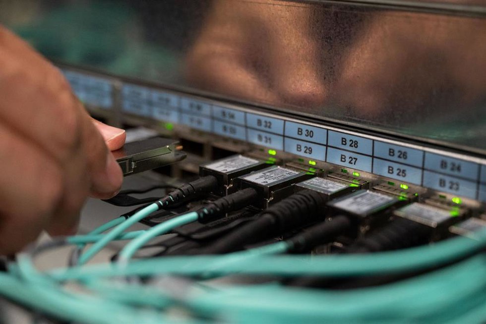 Archivo - FILED - 05 October 2021, Baden-Wuerttemberg, Stuttgart: An employee of the High Performance Computing Centre HLRS connects a fibre optic cable. Extending internet speeds up to 1 gigabit per second across Germany is proceeding apace, with 4 mil