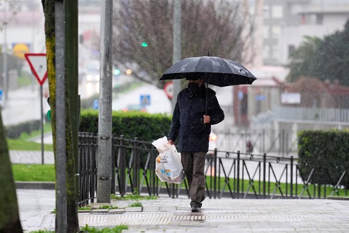 Archivo - Un hombre andando bajo la lluvia en Santander