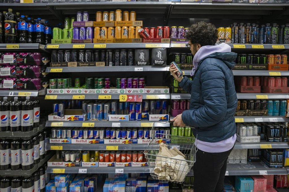 Archivo - Un joven mira la sección de bebidas energéticas en el supermercado