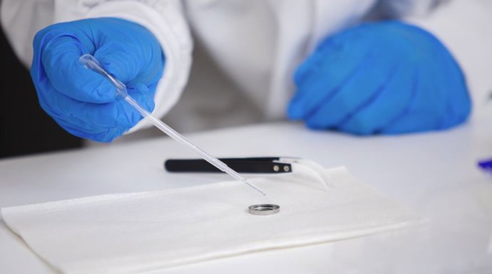 El profesor Tianyi Ma añade agua como electrolito a una batería pequeña.