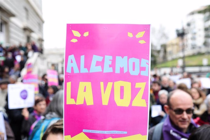 Archivo - Participante en la concentración de la plataforma Revuelta de Mujeres en la Iglesia junto a la catedral de la Almudena lleva un cartel que dice 'Alcemos la voz', en Madrid (España) a 1 de marzo de 2020.