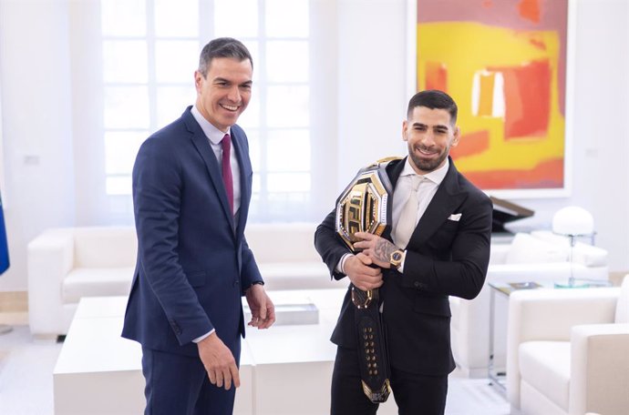 El presidente del Gobierno, Pedro Sánchez (i), recibe al luchador de artes marciales mixtas Ilia Topuria (d), que le muestra el cinturón de la UFC,  tras proclamarse campeón mundial de la UFC en la categoría de peso pluma, en el Palacio de La Moncloa, a 2