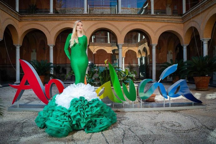 Una modelo exhibe el vestido creado por el diseñador cordobés José Perea con los colores de Andalucía con motivo del 28F.
