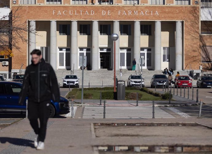 Archivo - Una persona camina junto a la Facultad de Farmacia