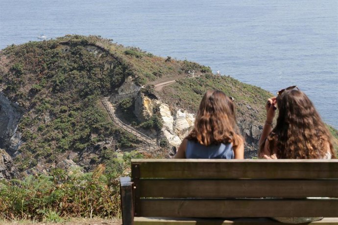 Archivo - Dos jóvenes realizan la ruta Punta Socastro o O Fuciño do Porco, a 11 de agosto de 2022, en O Vicedo, Lugo, Galicia (España). O Fuciño do Porco significa hocico de cerdo en castellano y esconde el cabo donde se localiza una ruta impresiona