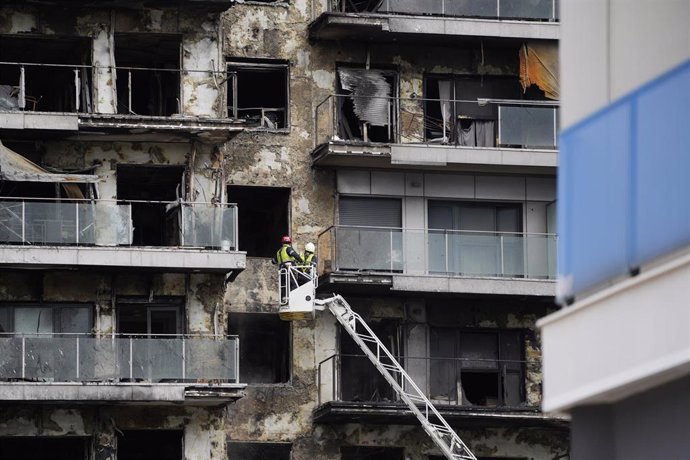 Bomberos trabajan en la limpieza del edificio incendiado, en el barrio de Campanar. 