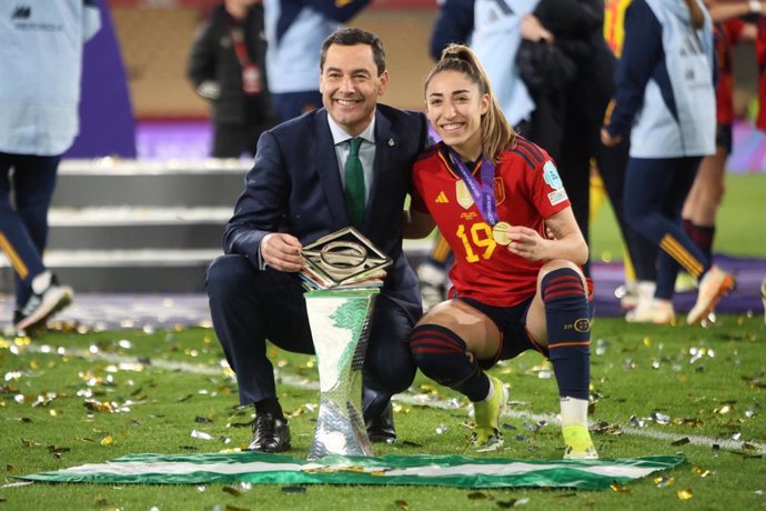 El presidente de la Junta de Andalucía, Juanma Moreno, junto a la jugadora Olga Carmona tras la conquista de la Nations League por la selección femenina de fútbol en el estadio de La Cartuja de Sevilla