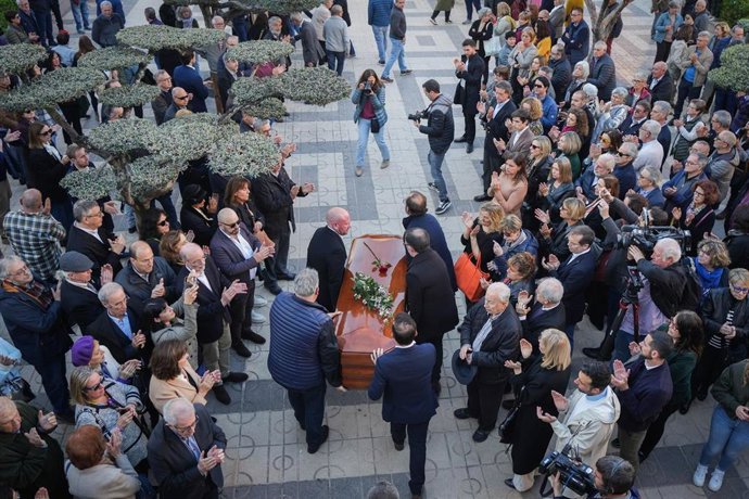 Varias personas transportan el féretro durante la capilla ardiente del escritor y periodista Fernando Delgado