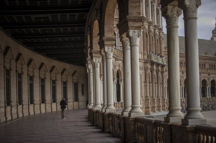 Archivo - Un turista pasea por las galerías de la Plaza de España en Sevilla (Andalucía, España).