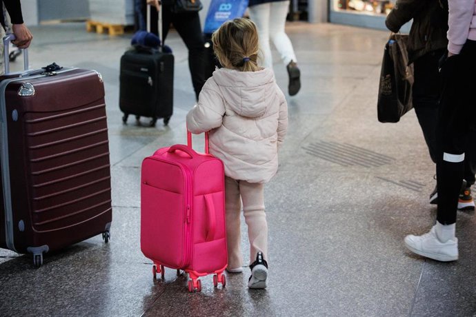 Archivo - Una niña con su maleta, durante la operación salida con motivo de las fiestas navideñas, en la estación de Atocha, a 22 de diciembre de 2023, en Madrid (España).