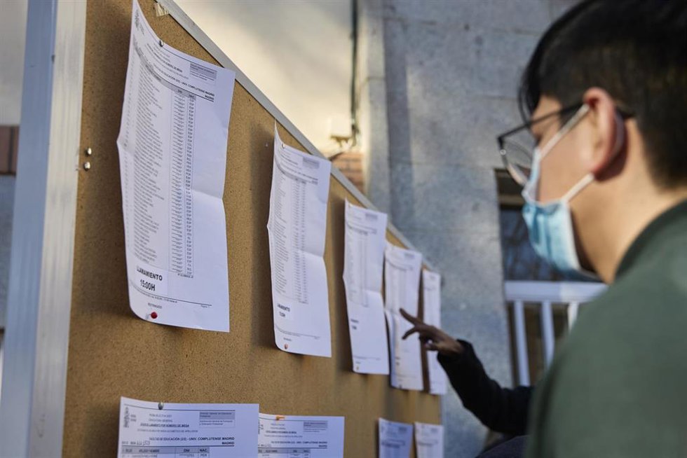 Archivo - Varias personas consultan los listados en una convocatoria de exámenes MIR.
