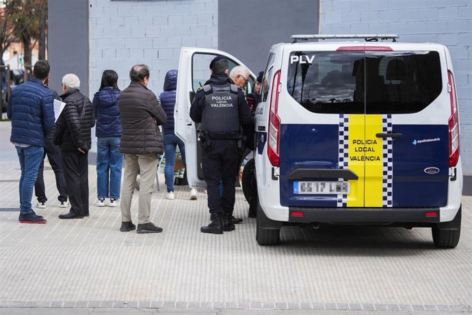 Agentes de la Policía Nacional junto a los afectados del edificio incendiado en el barrio de Campanar
