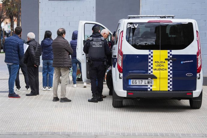 Agents de la Policia Nacional junt amb els afectats de l'edifici incendiat al barri de Campanar