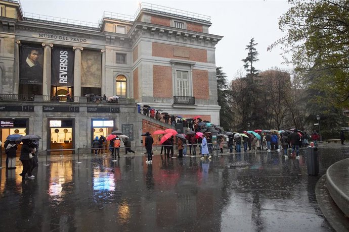 Decenas de personas con paraguas hacen cola en el exterior del Museo del Prado para realizar una visita de noche, a 2 de marzo de 2024, en Madrid (España). 