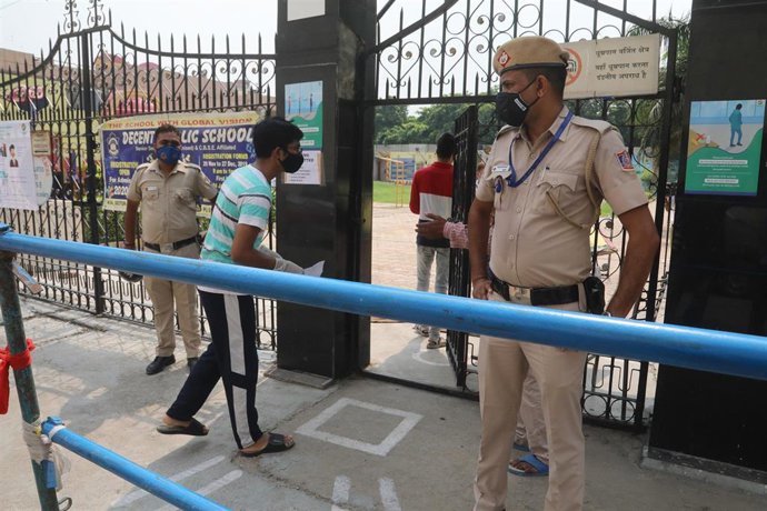 Archivo - Policías con mascarilla en la puerta de un centro de exámenes en Nueva Delhi