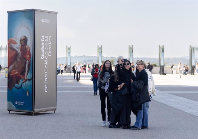 Grupo de turistas tomándose una fotografía, en las inmediaciones del Palacio Real de Madrid.