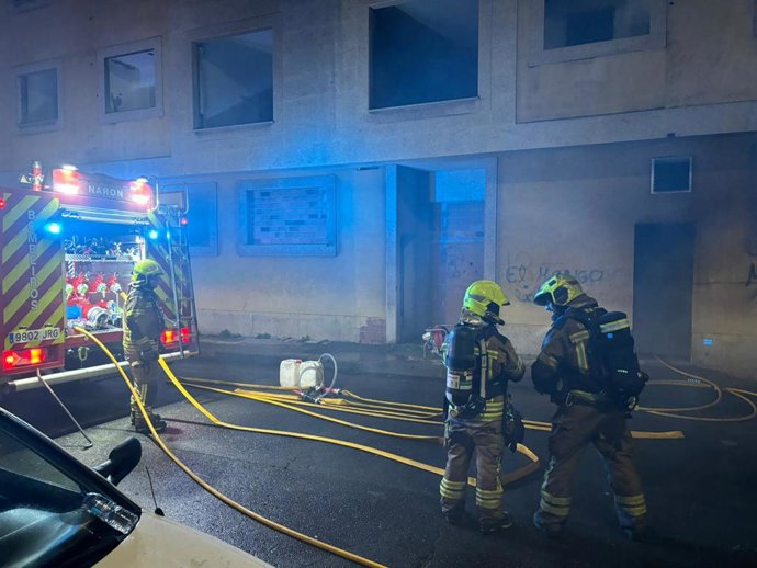 Bomberos trabajan en la extinción de un incendio en un edificio abandonado en Narón (A Coruña).
