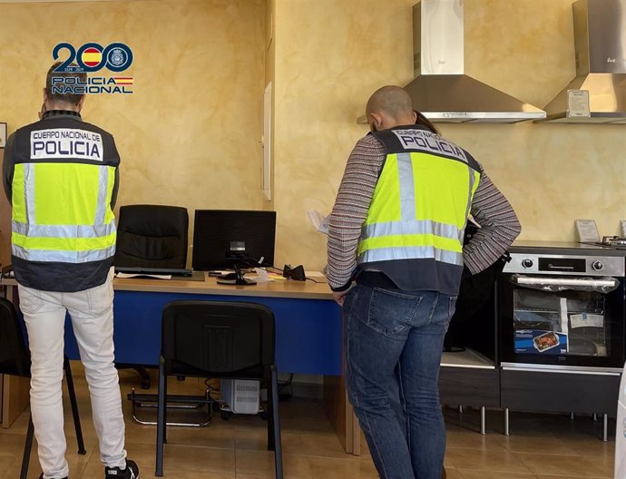 Dos agentes de Policía Nacional inspeccionan la tienda de electrodomésticos