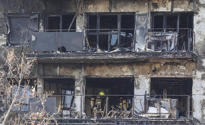 Dos agents de la Policia Científica cerquen les causes de l'incendi a l'edifici del barri de Campanar