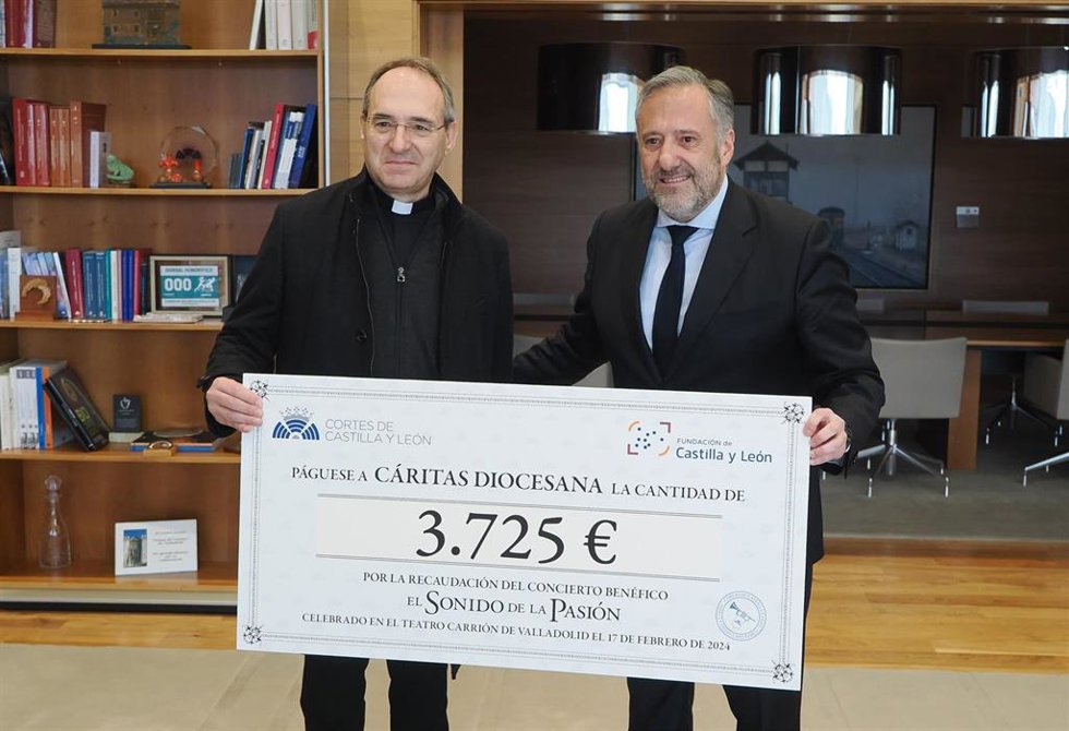El presidente de las Cortes de Castilla y León, Carlos Pollán, entrega al presidente de Cáritas Castilla y León, Antonio Jesús Martín de Lera, el donativo en un acto simbólico.