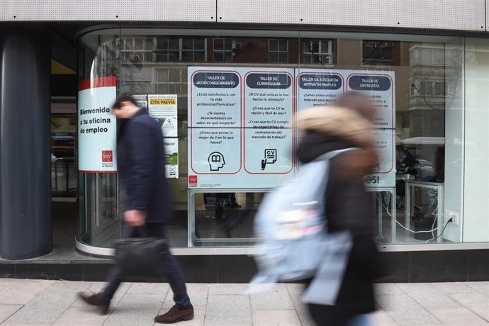 Dos personas pasan por una oficina de empleo de la Comunidad de Madrid, a 4 de marzo de 2024, en Madrid (España). 