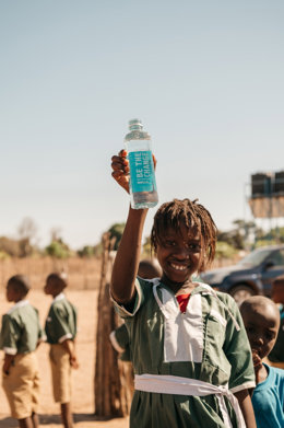Niño sujetando una botella de la empresa AUARA.