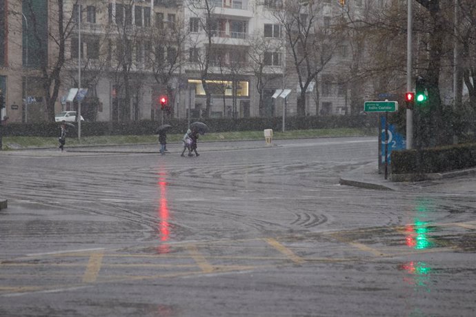 Varias personas cruzan una calle durante la tormenta, en el centro de Madrid, a 2 de marzo de 2024, en Madrid (España). La Agencia Estatal de Meteorología (AEMET) ha activado el aviso amarillo en la Comunidad de Madrid por fuertes rachas de viento de hast