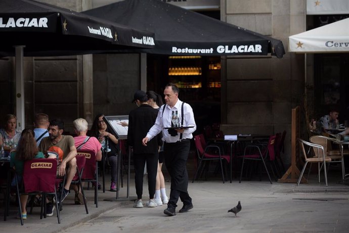 Archivo - Un camarero sostiene una bandeja en la plaza Real de Barcelona, en Barcelona, Catalunya (España), foto de archivo. 